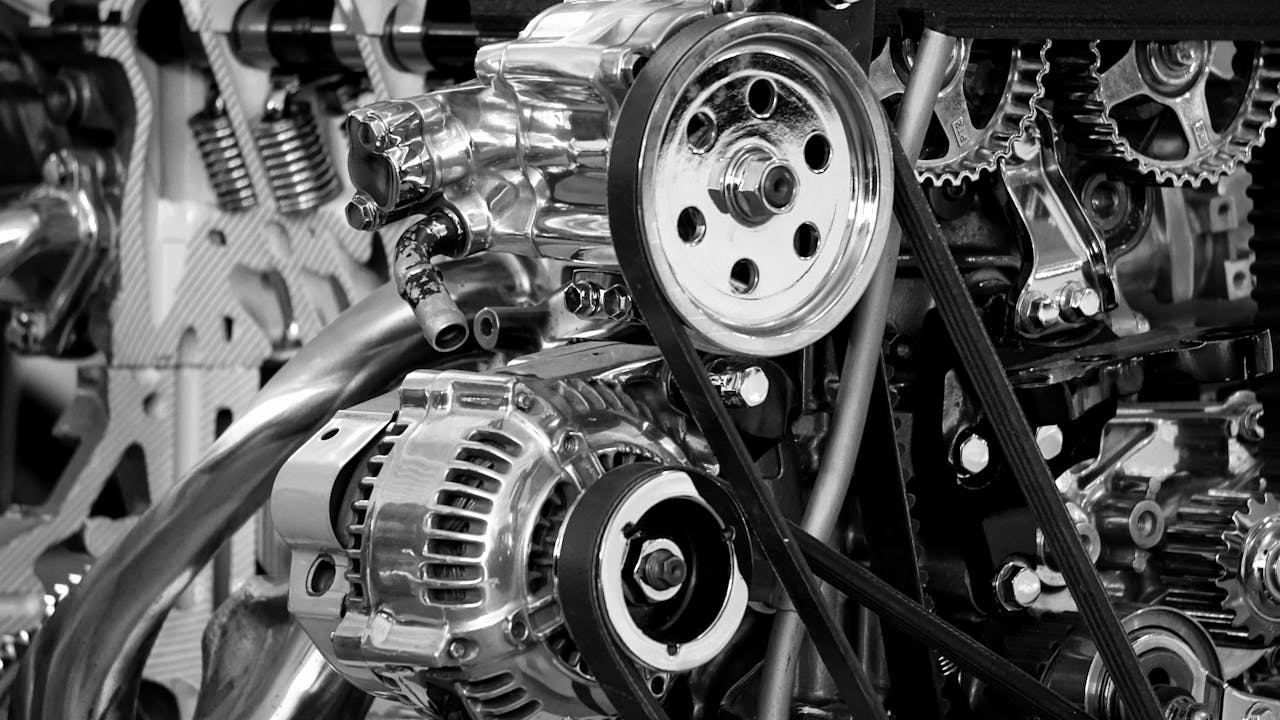 home-hero Close-up of a shiny car engine showing polished metal parts and gears in black and white.