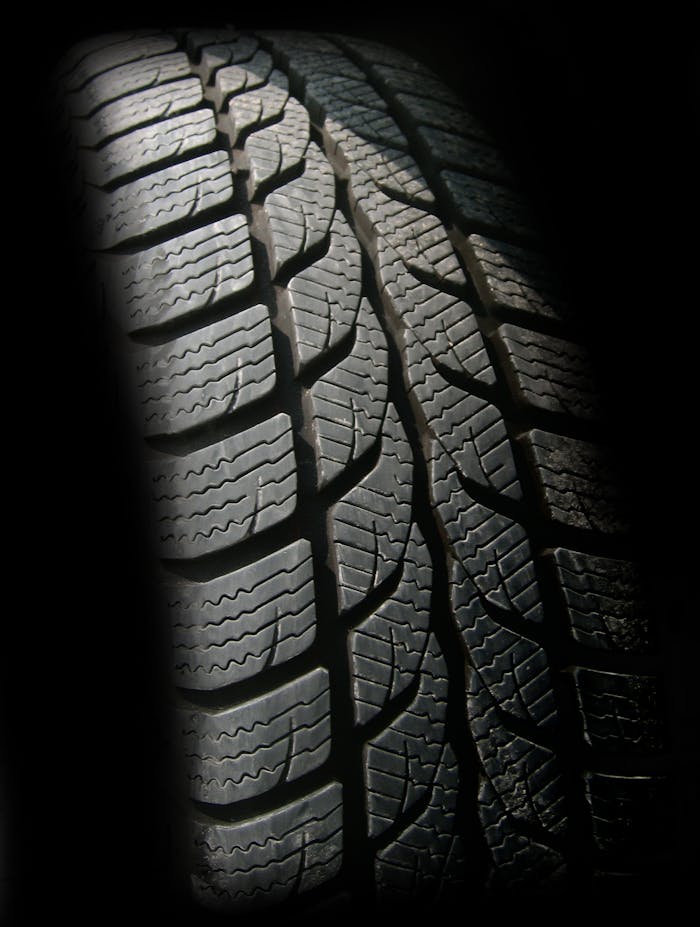 get-in-touch Detailed close-up image of a rubber tire showcasing texture and tread pattern, ideal for design concepts.